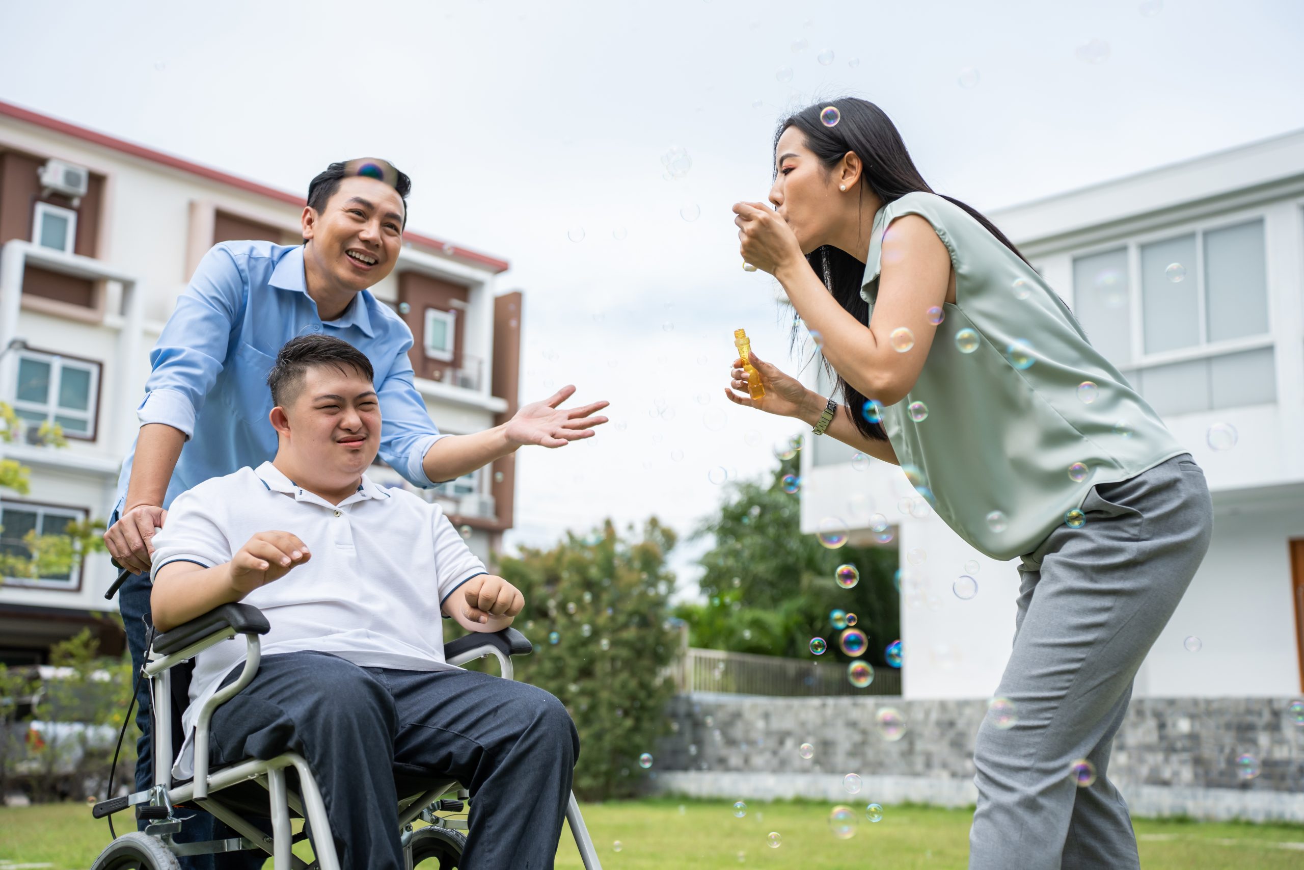 In Sample Post #3, a woman playfully blows bubbles in front of a man in a wheelchair, as another man stands behind her, smiling warmly amidst the lush garden setting.